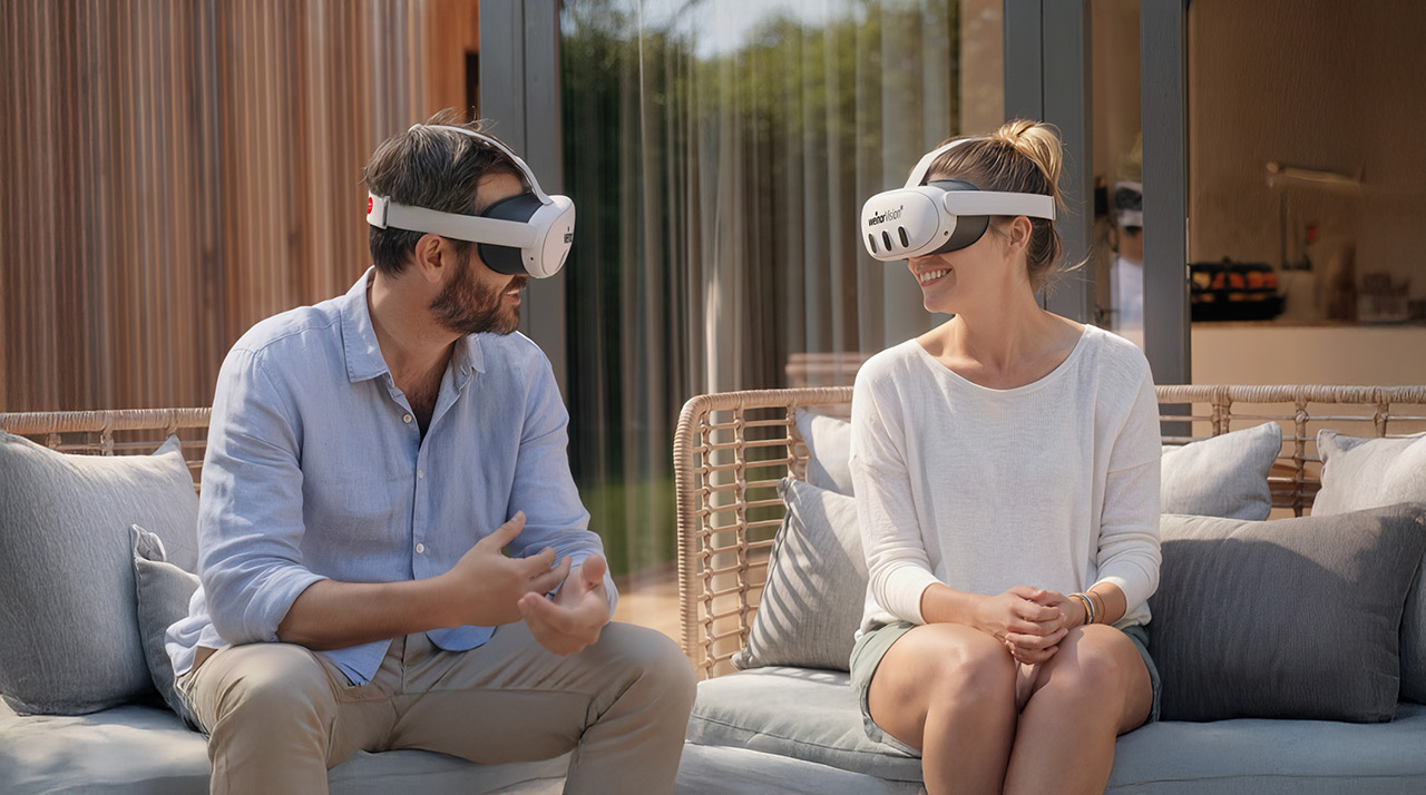 Deux personnes portant des casques de réalité virtuelle, assises sur un canapé.