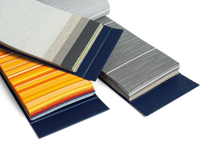 Échantillons de tissu avec des rayures et des textures variées, dominés par des couleurs jaune, gris et bleu. Échantillons de tissu avec des rayures et des textures variées, dominés par des couleurs jaune, gris et bleu.