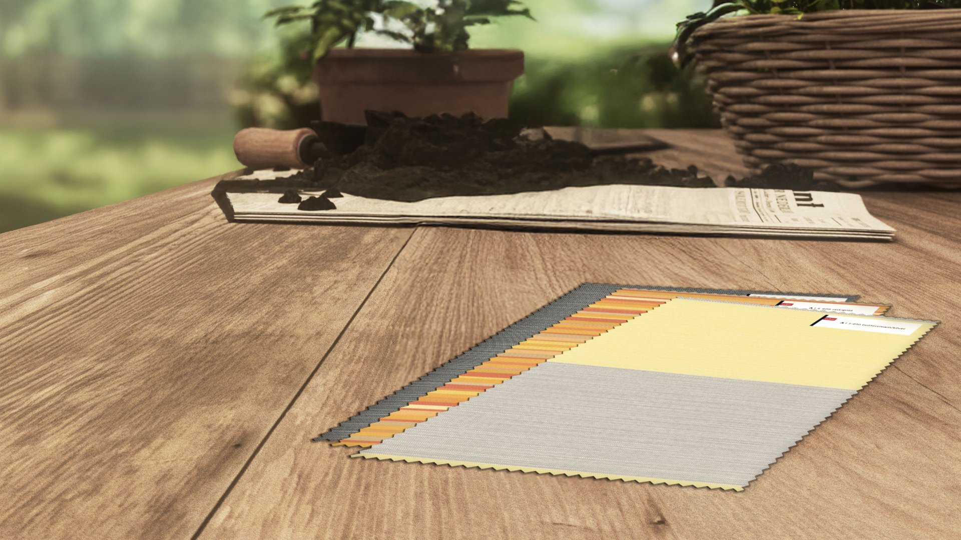 Farbenfrohe Stoffmuster auf einem Holztisch, umgeben von Erde und einem Korb mit Pflanzen.