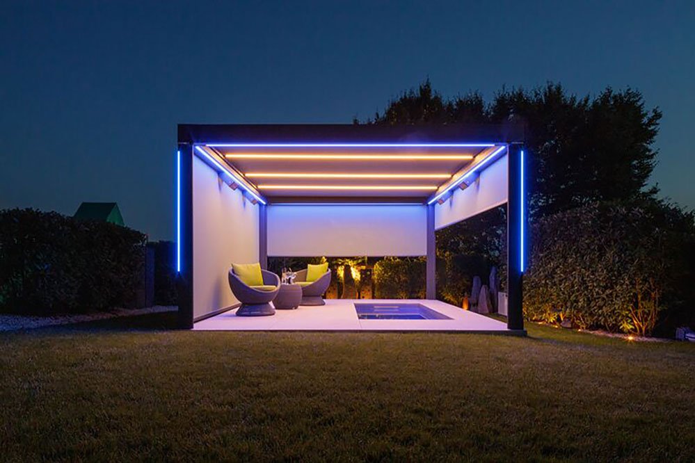 Sur une terrasse illuminée, une structure moderne avec un éclairage LED et des fauteuils, entourée de verdure. Sur une terrasse illuminée, une structure moderne avec un éclairage LED et des fauteuils, entourée de verdure.