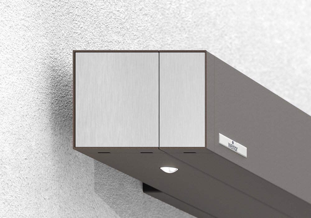 Store de terrasse Smaila avec cassette cubique, couleur de la structure gris, monté sur une façade moderne