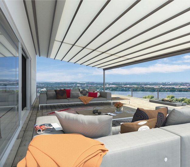 Terrasse avec une surstructure, offrant une vue dégagée, des canapés et des assises confortables. 