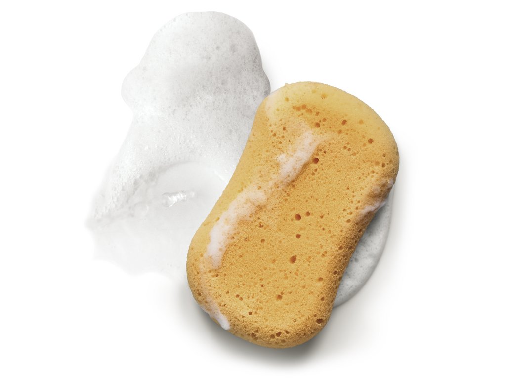 Éponge beige avec des bulles de mousse blanche à côté. Éponge beige avec des bulles de mousse blanche à côté.