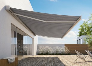 Une grande marquise grise sur une terrasse en bois, avec un ciel bleu en arrière-plan. 