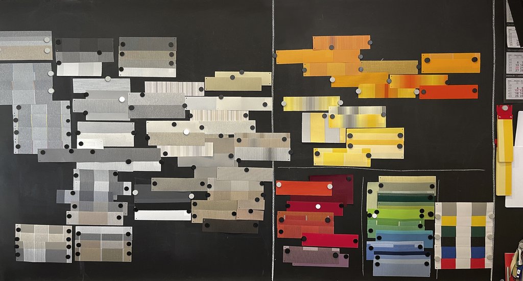 Échantillons de couleurs variées sur fond noir, dispose des nuances de gris, orange et rouge.