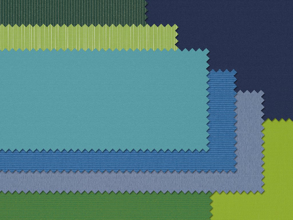 Échantillons de tissus en différentes nuances de bleu, vert et beige, disposés en couches.