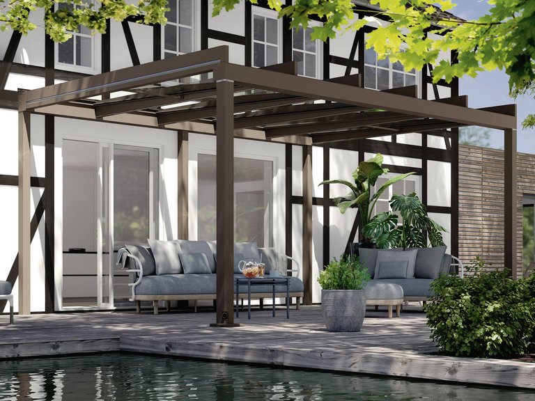 Terrassensituation mit Überdachung und Sitzgelegenheiten, umgeben von Pflanzen und einem Wasserbecken.