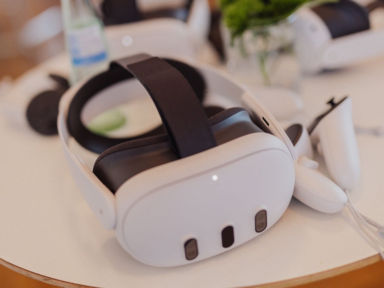 Casque de réalité virtuelle blanc avec des accents noirs, posé sur une surface circulaire.