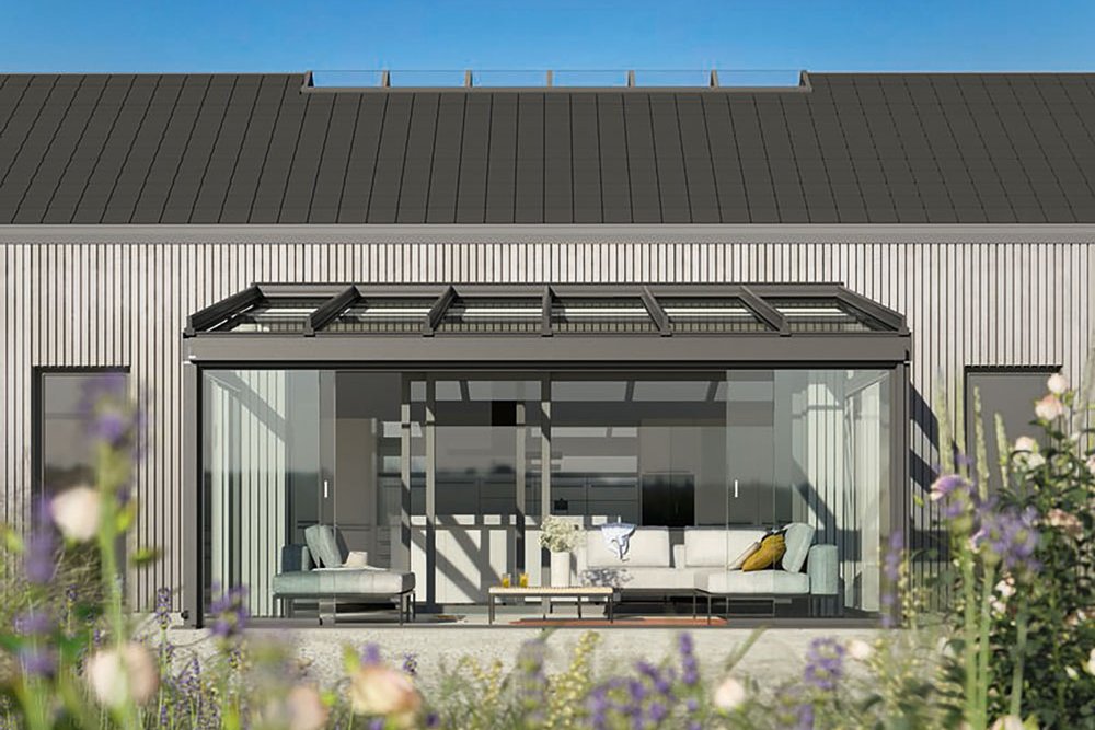 Maison moderne avec une surélévation en verre, ciel bleu et fleurs en premier plan. Maison moderne avec une surélévation en verre, ciel bleu et fleurs en premier plan.