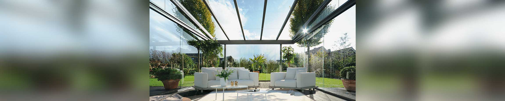 Espace extérieur moderne avec un toit en verre, mobilier minimaliste et verdure environnante. Espace extérieur moderne avec un toit en verre, mobilier minimaliste et verdure environnante.