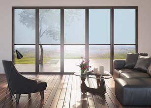 Intérieur moderne avec de grandes fenêtres, des fauteuils élégants et une vue sur l'extérieur verdoyant. 