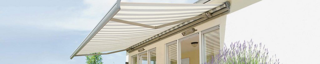 Marquise rayée en tissu blanc et beige, installée au-dessus d'une terrasse. Marquise rayée en tissu blanc et beige, installée au-dessus d'une terrasse.