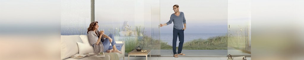 Deux personnes dans une situation de terrasse avec vue sur la mer, entourées de verre transparent. Deux personnes dans une situation de terrasse avec vue sur la mer, entourées de verre transparent.