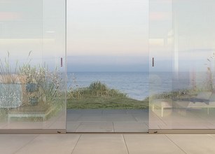 La paroi coulissante en verre sans cadre offre toujours une transparence complète pour une vue dégagée depuis la terrasse. 