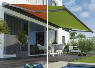 Image montrant une maison avec une store orange et une store verte, sur un patio en bois. 