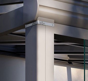 Détails d'une structure avec un angle, des éléments métalliques et des surfaces en verre.
