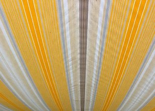 Tissu rayé aux teintes jaune, beige et blanc, présenté en forme arrondie. 